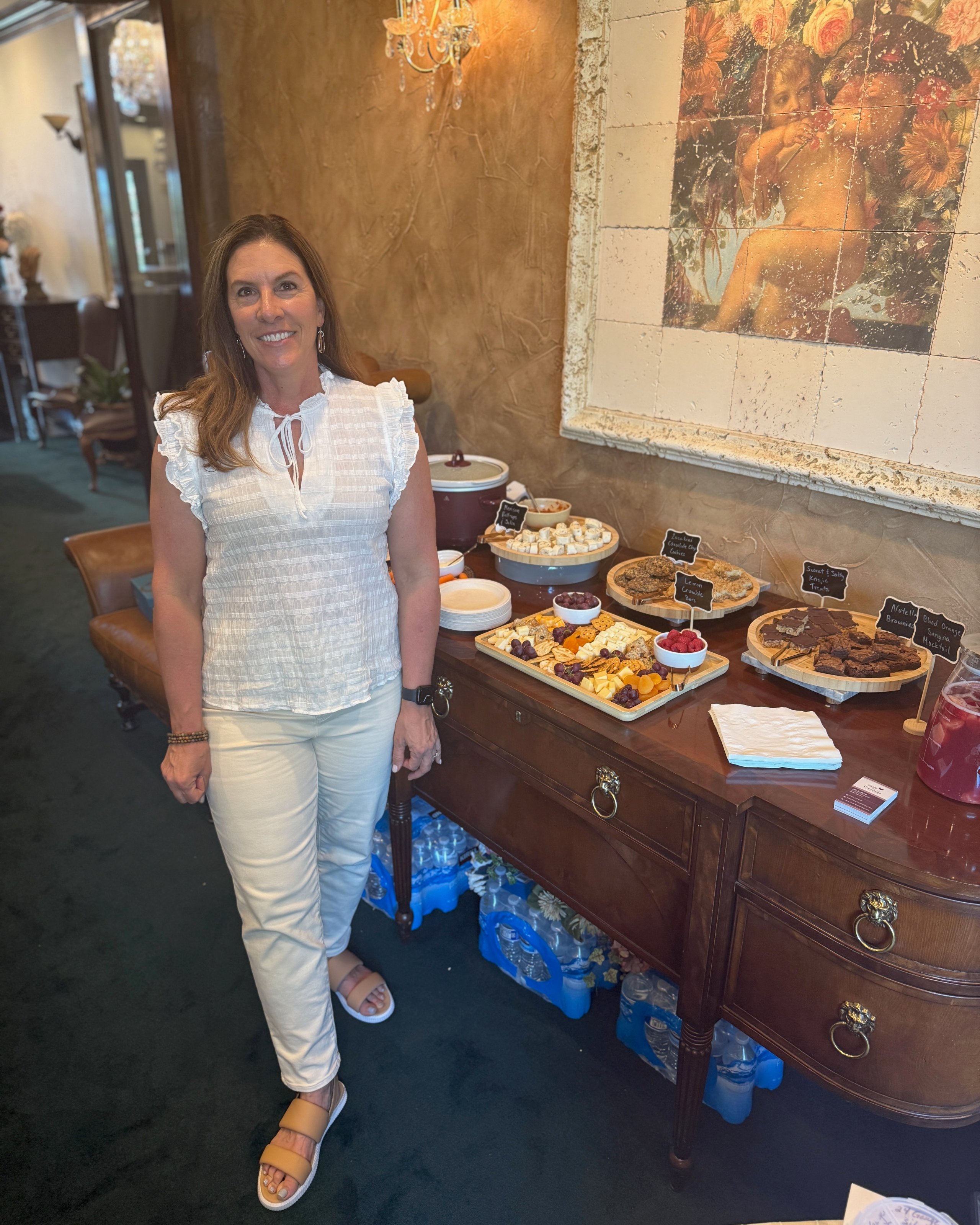 Woman standing next to buffet table with various snacks and chalkboard labels