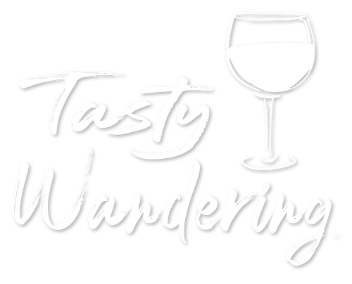 Tasty Wandering logo with cursive text and wine glass silhouette