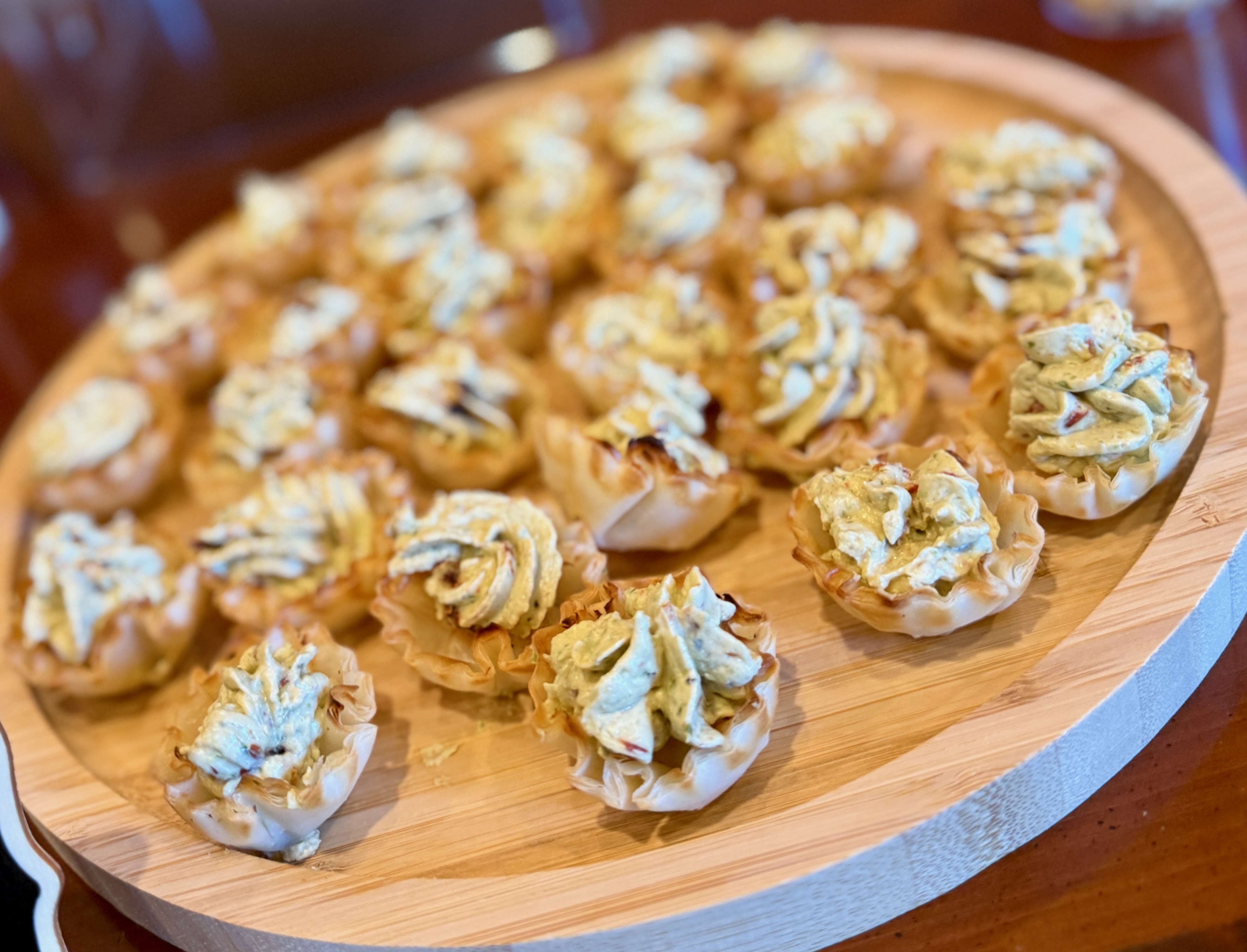 Tasty, wandering appetizers on wooden board with delicate pastry swirls