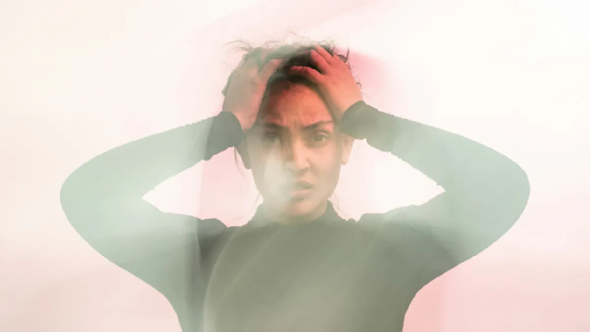 Distressed woman holding her head, illustrating the difference between stress and anxiety