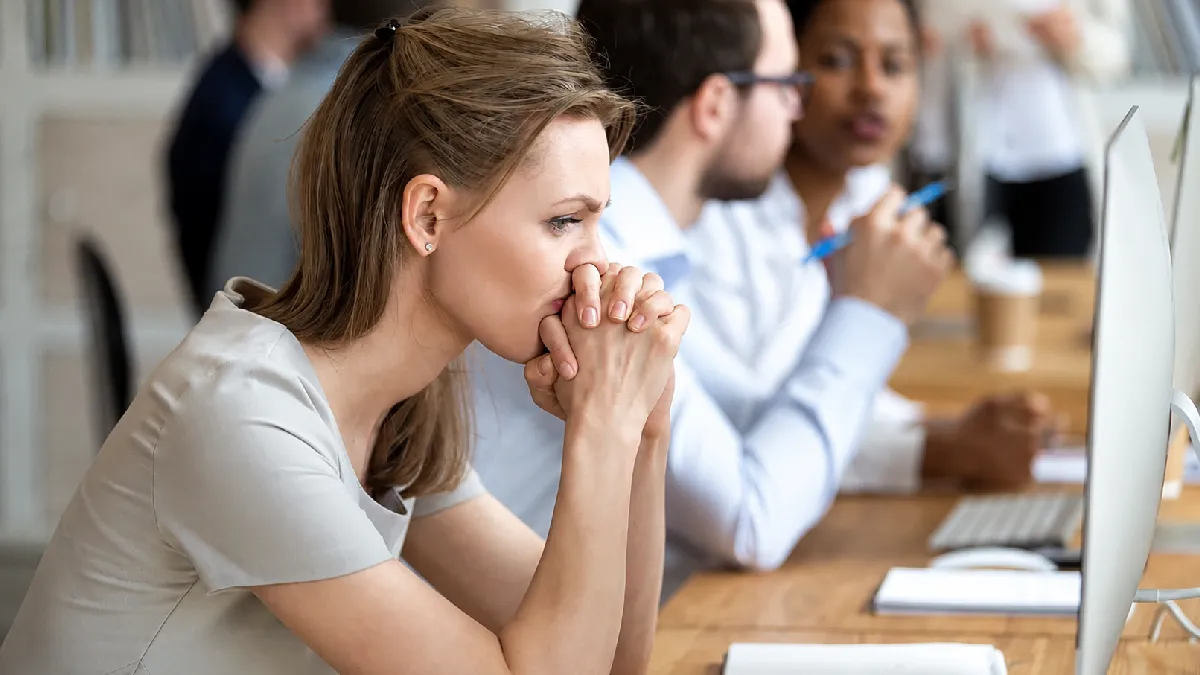 Concerned employee at her desk, illustrating how to identify workforce health risks before they lead to absence
