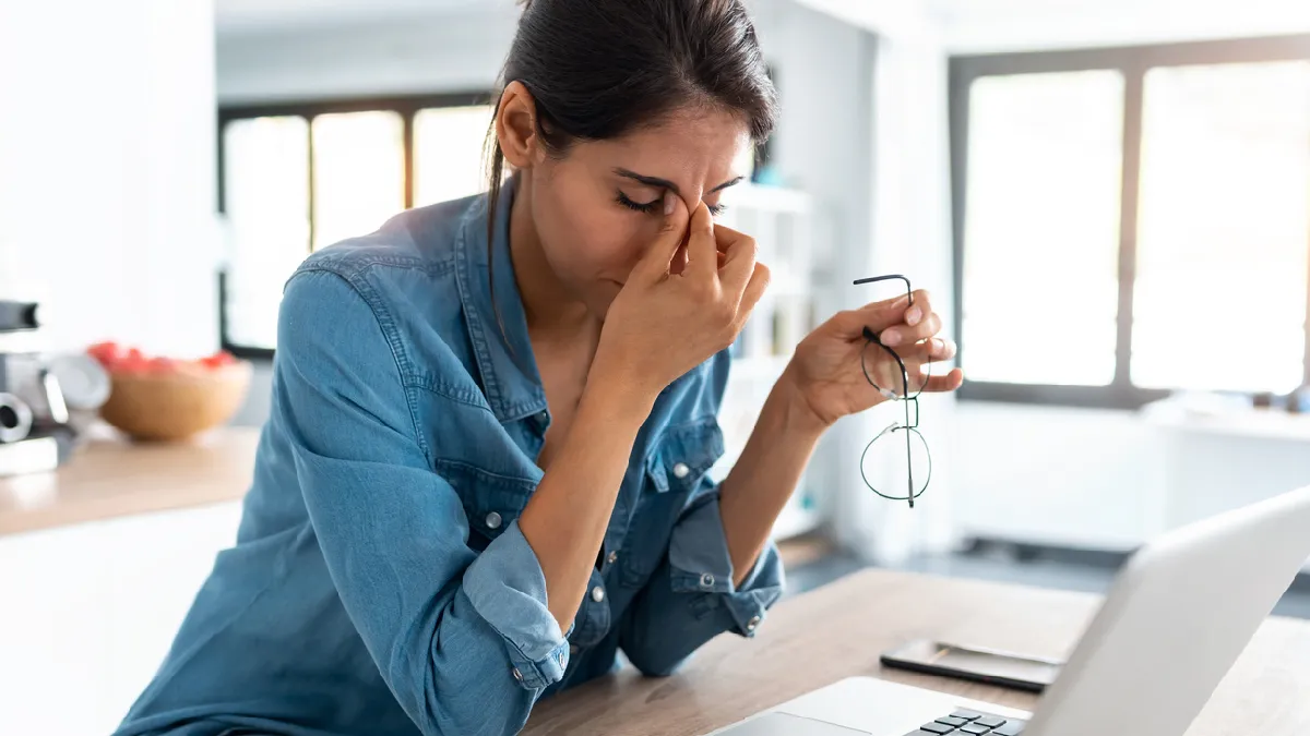 Employee taking a break from her laptop during an April spotlight on managing stress and burnout