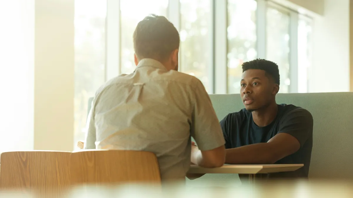 Two colleagues in conversation, illustrating why performance is not a reliable measure of personal capacity