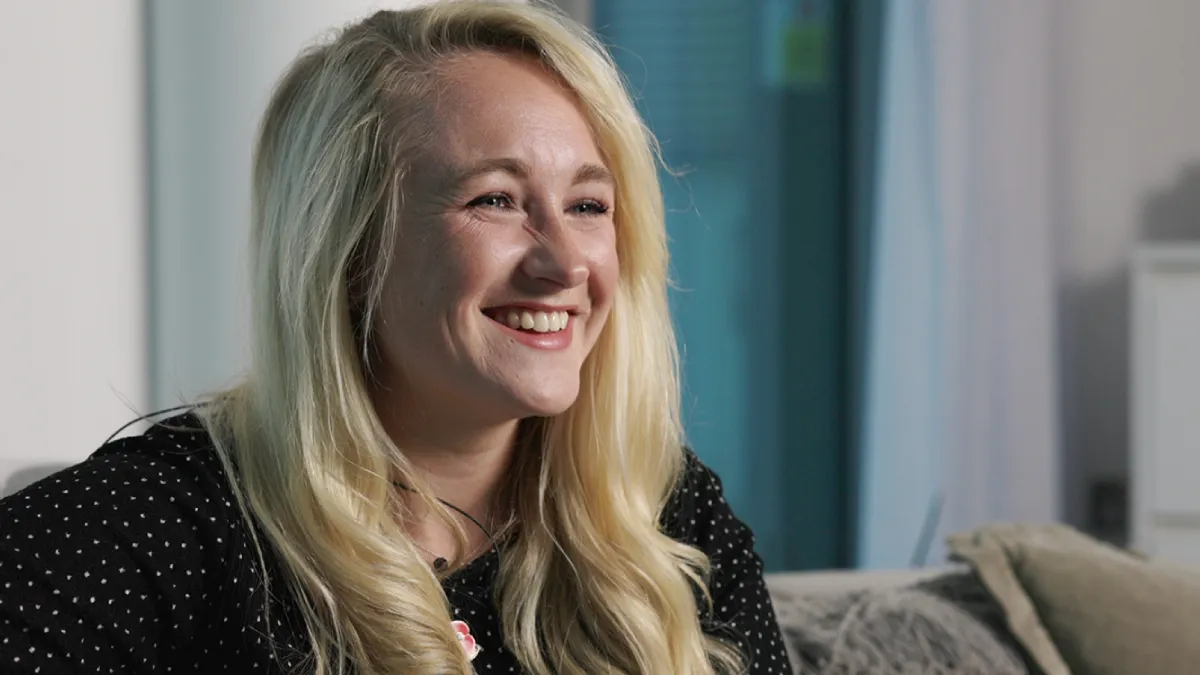 Smiling Strata team member discussing the wellbeing programme that reduced work-related stress by 68%