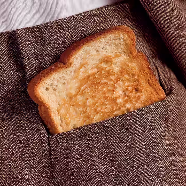 Eine Scheibe Toastbrot steckt in einer braunen Stofftasche.