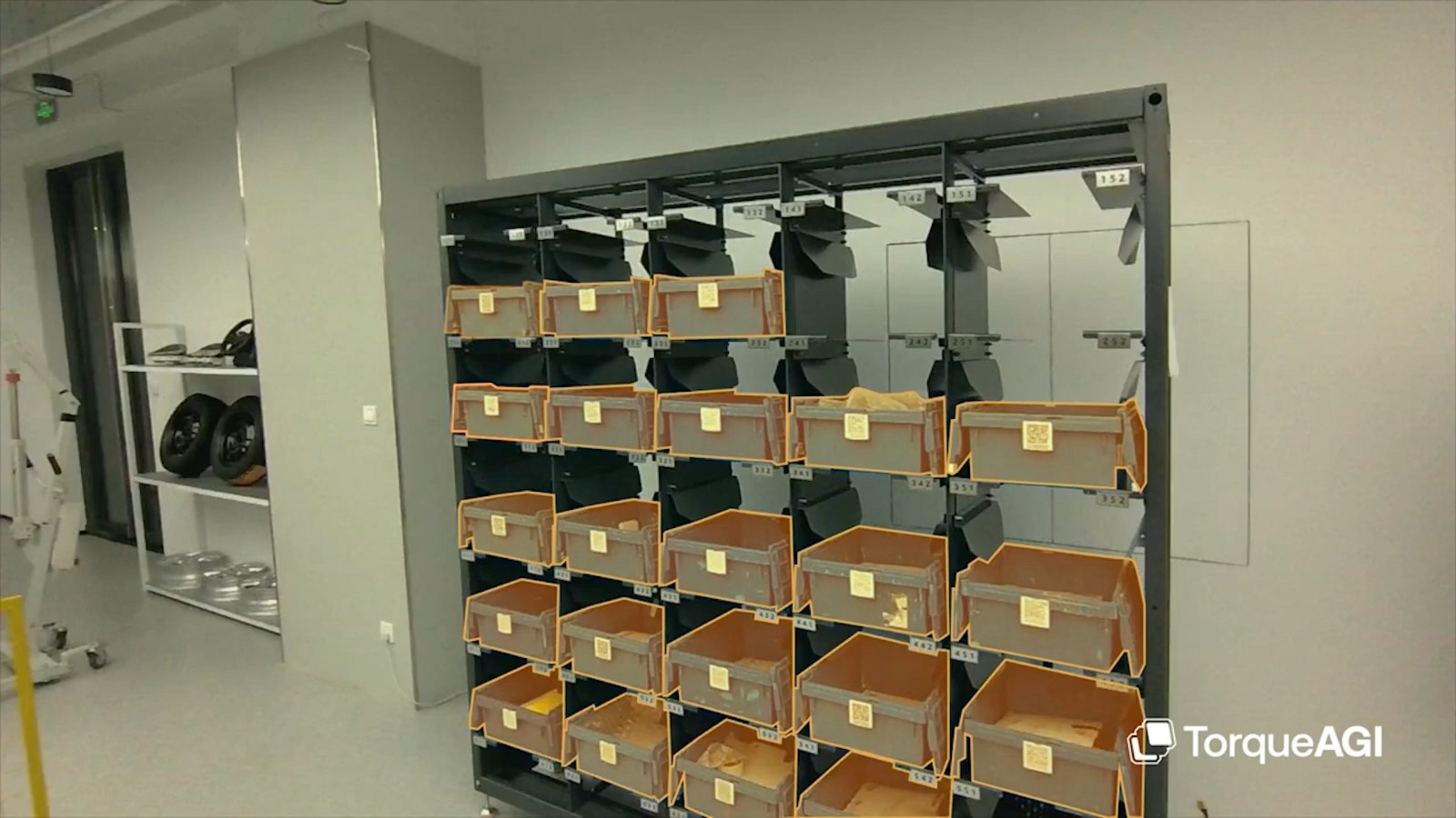 TorqueFlow: a warehouse bin rack with each tote outlined by an orange segmentation mask