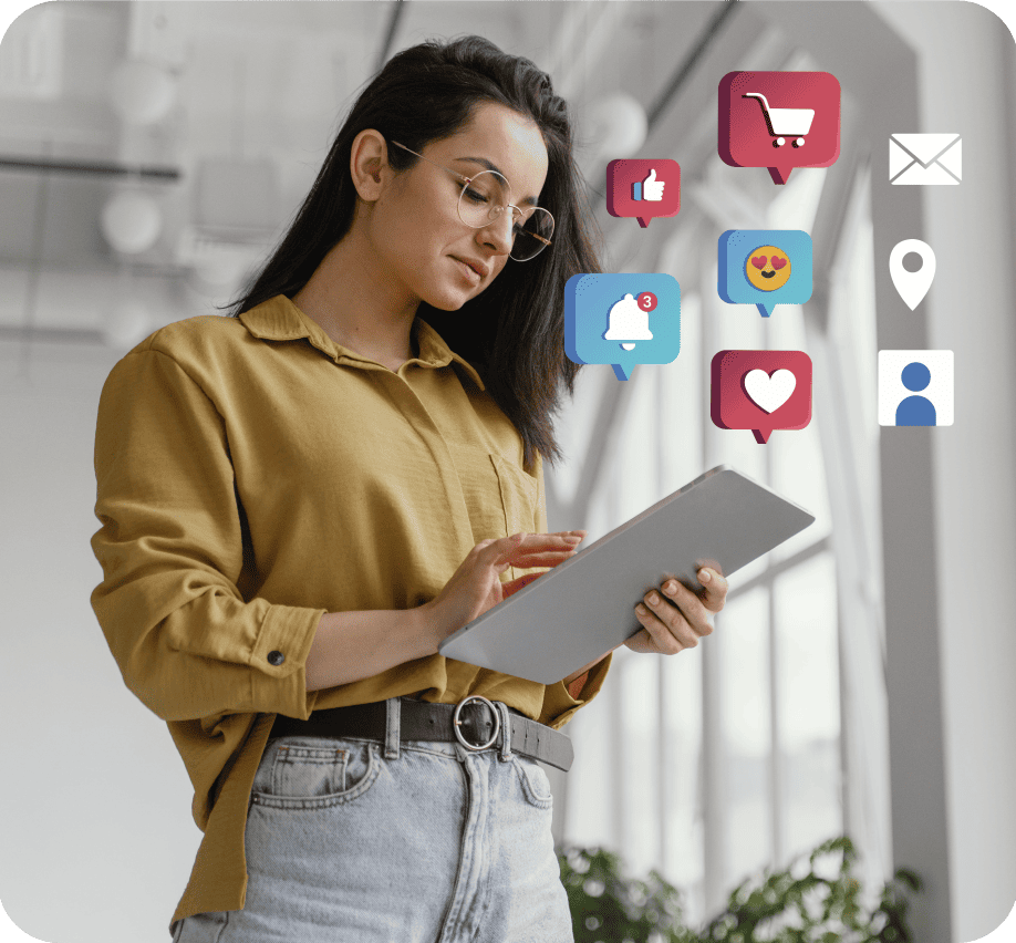 Young woman wearing glasses and a mustard shirt using a tablet with floating social media icons including like, shopping cart, notification, heart, emoji, email, location, and user profile.