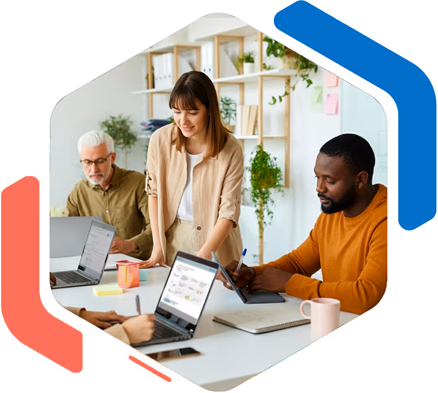 Un groupe diversifié de collègues travaillant ensemble dans un bureau lumineux avec des ordinateurs portables et un tableau blanc en arrière-plan.