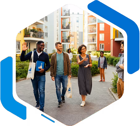 Groupe de jeunes adultes marchant et discutant dans une cour résidentielle moderne avec des immeubles colorés en arrière-plan.