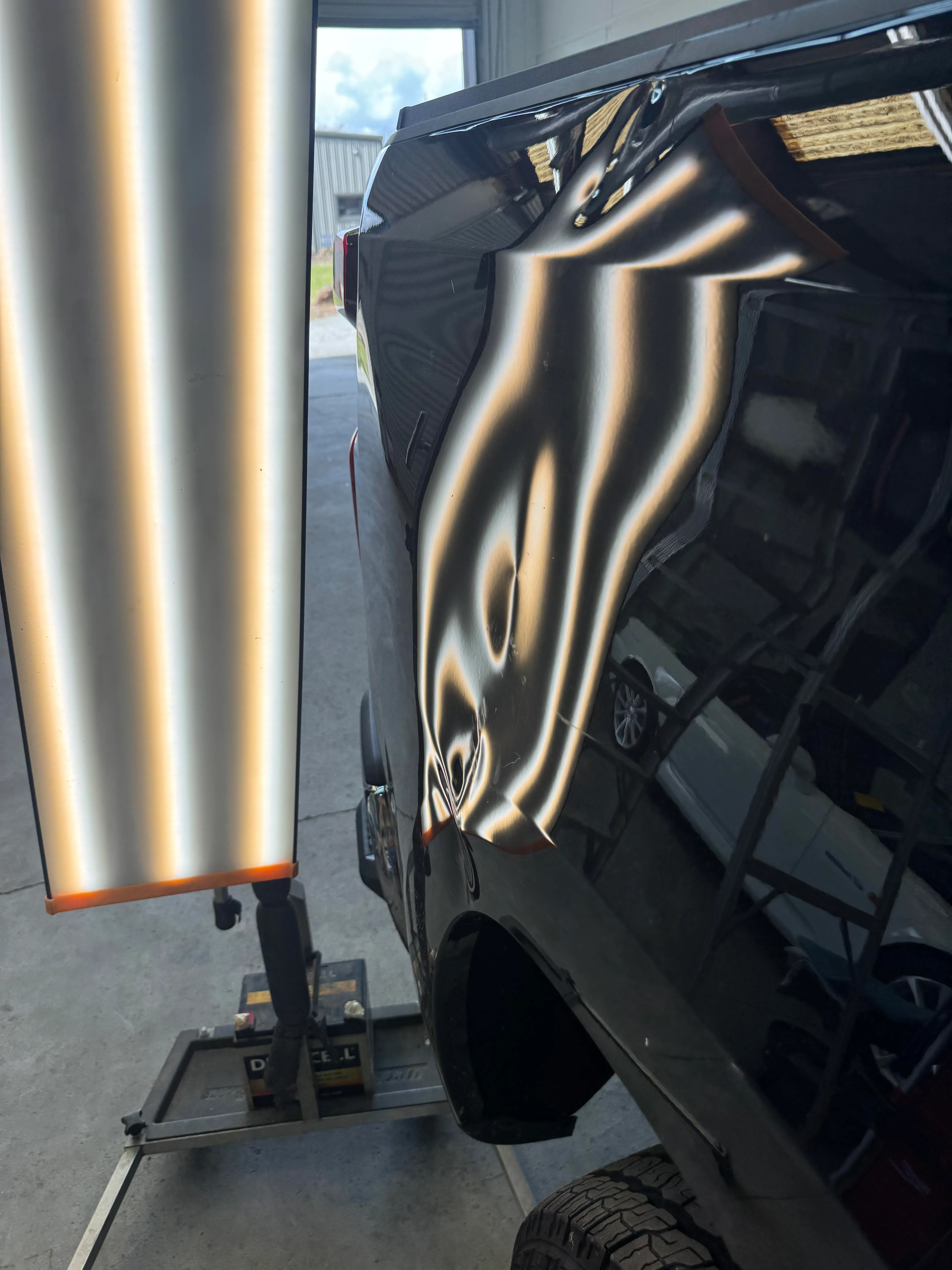 Door panel with a large dent before paintless dent repair