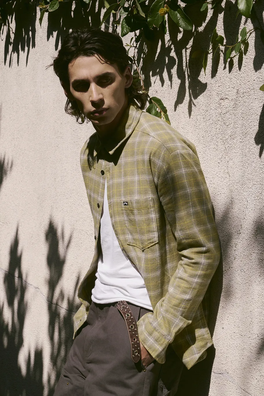 Stylish man in a green checked shirt and brown trousers