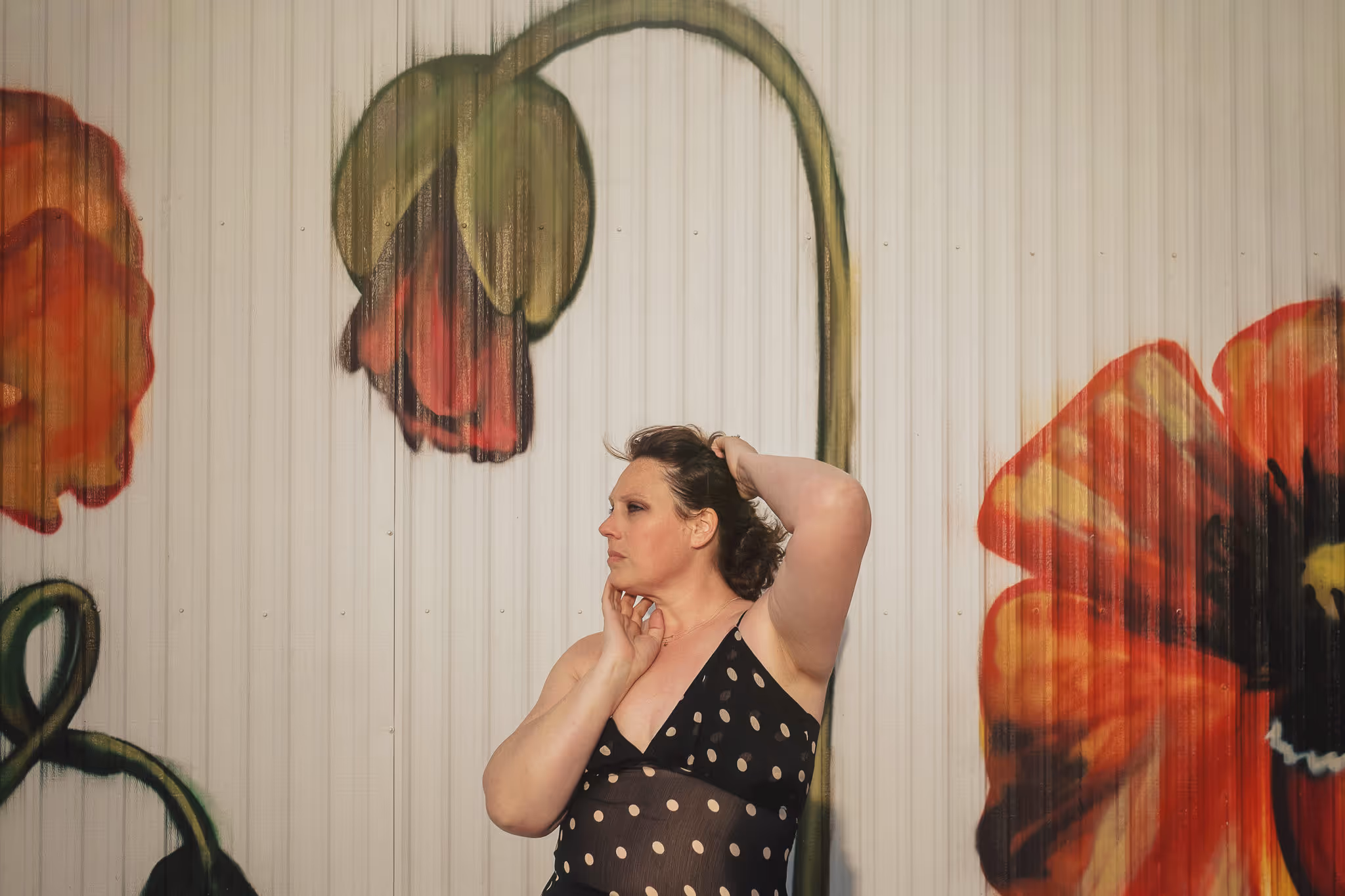 Portrait photo of Katie standing in front of a mural