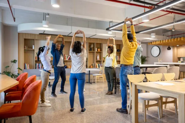 Grupo de empleados haciendo actividad física que promueve el wellness corporativo dentro de la empresa