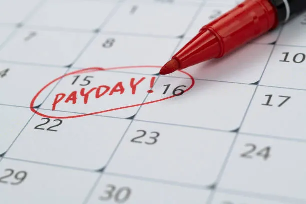 Agenda empresarial con fecha marcada y palabra Pay Day que ilustra la eficiencia de la maquila de nómina