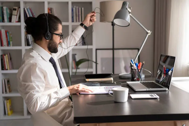 Hombre en oficina remota trabajando en su computadora, representando la productividad del teletrabajo