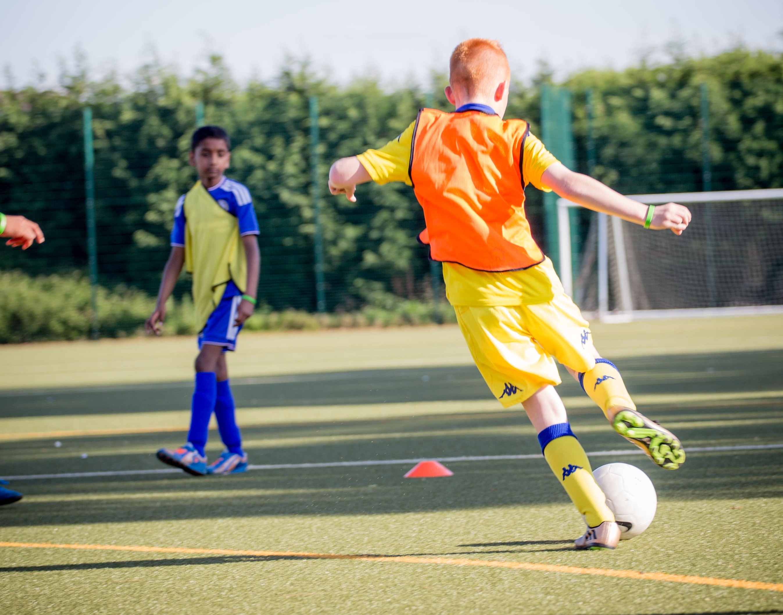 Children playing soccer outdoors, showing energy, focus, and teamwork.