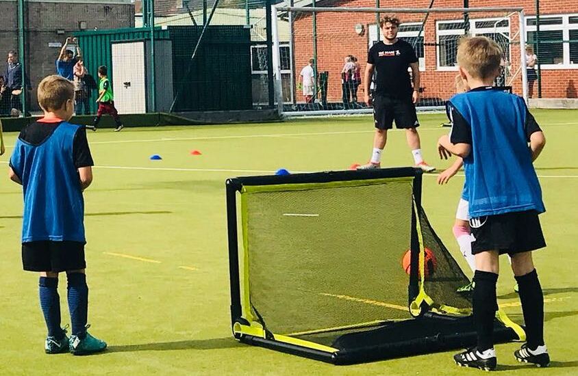 A group of children enjoying physical activity in a structured football session.
