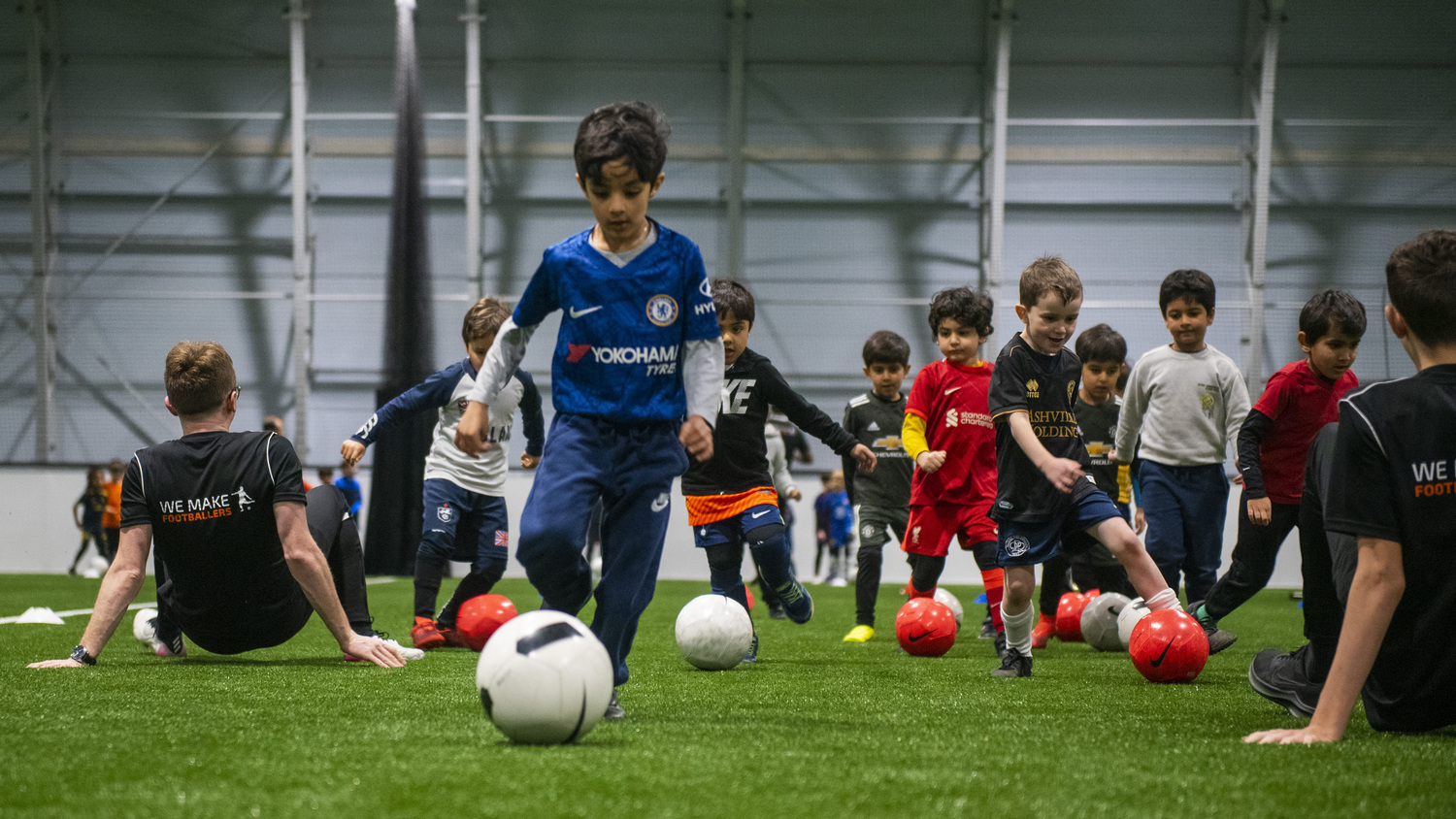 Children learning teamwork and football skills at We Make Footballers academy
