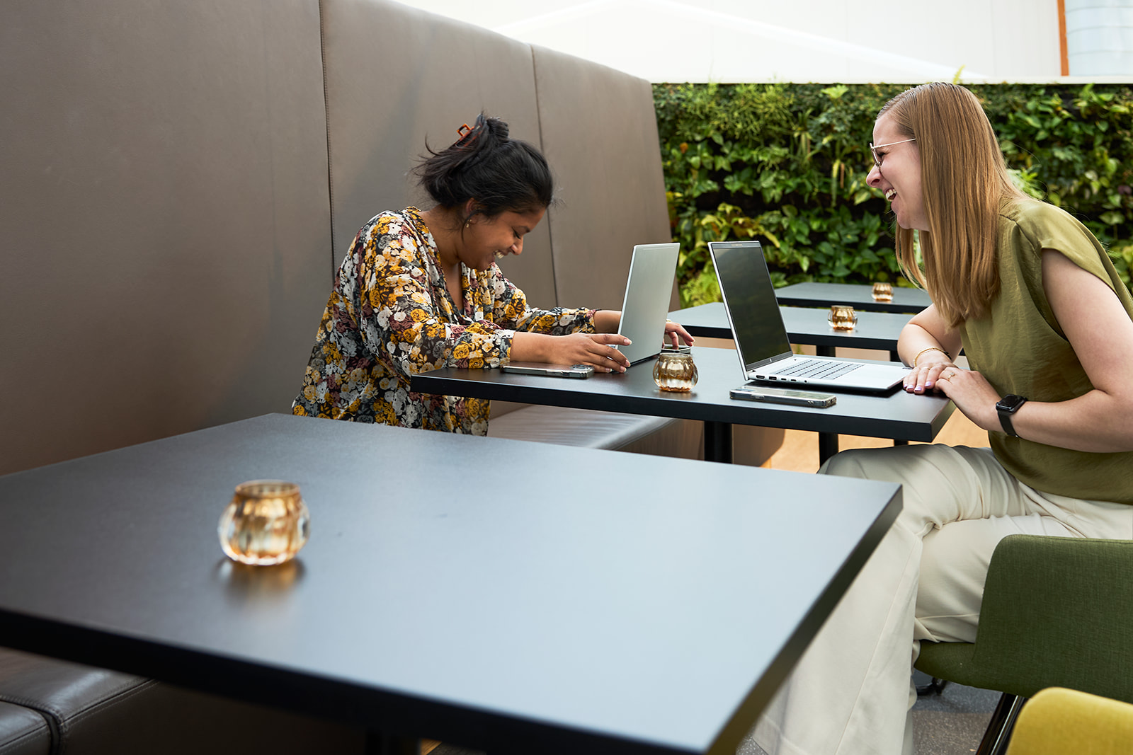 Tenderspecialist Daina Munnik lachend in overleg met tenderspecialist Famke van Hattem