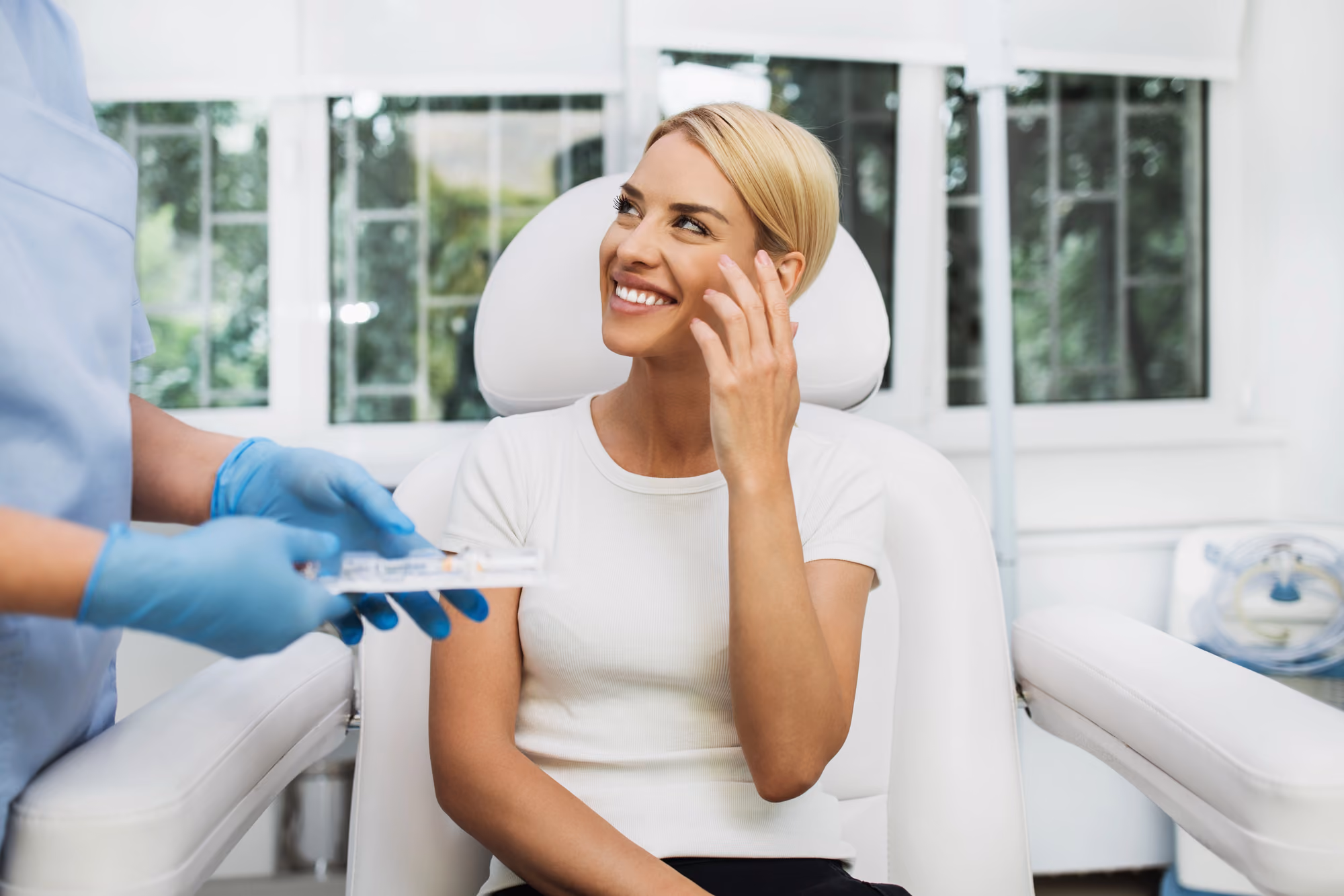 Smiling patient checking facial results during a Botox appointment at a cosmetic clinic in Richmond Hill