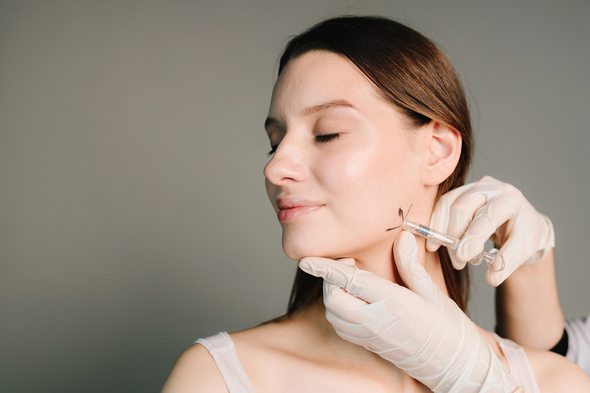 receiving jawline filler injection for lower face contouring