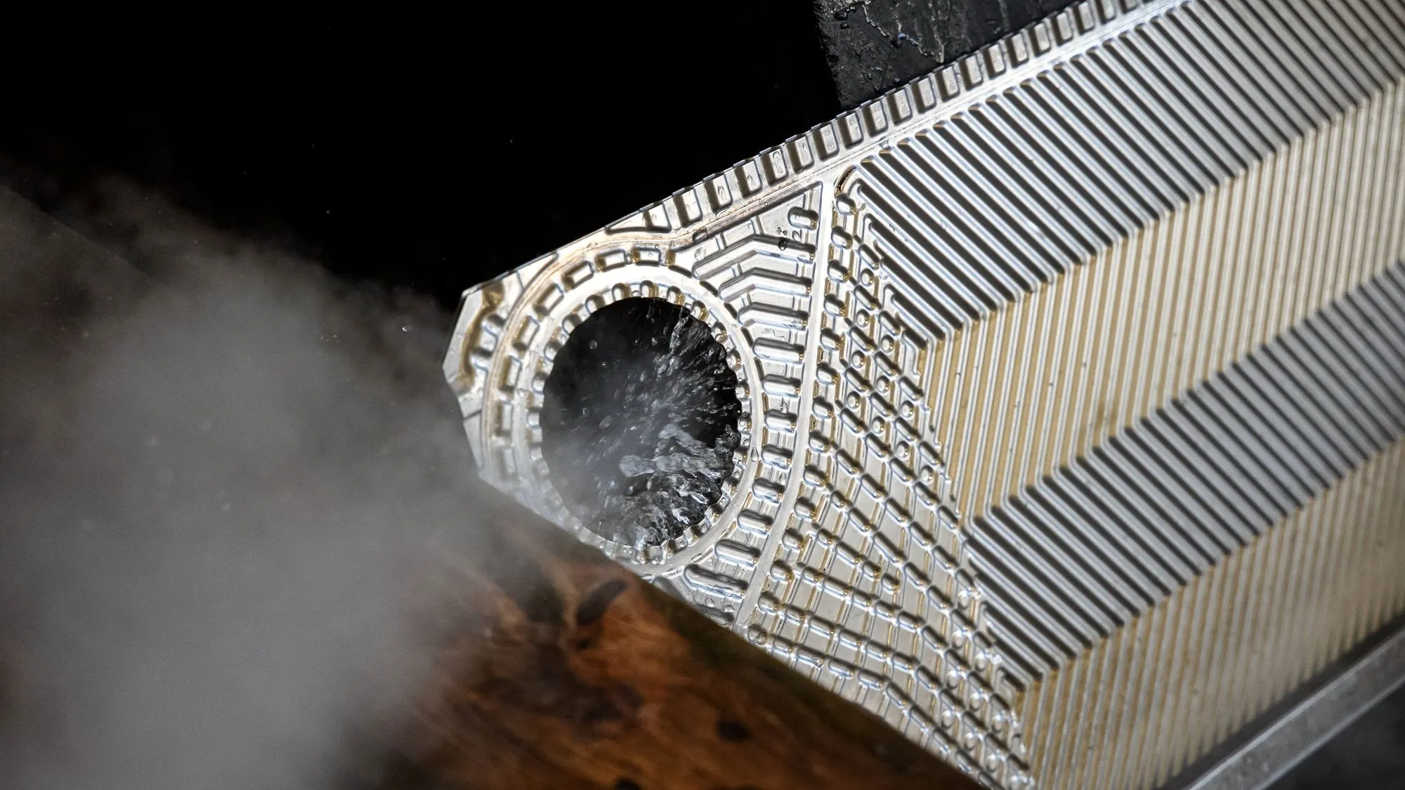 Metalvarmeveksler med damp, der bevæger sig ud fra en cirkulær åbning.