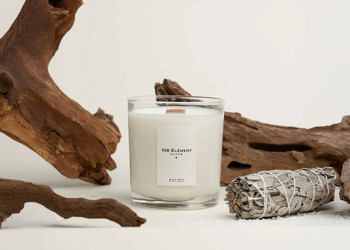 Picture of a candle. Next to it is salt, sage and aesthetic wood pieces