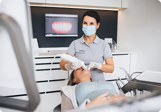 Dentist wearing a face mask using an intraoral scanner on a patient in a dental clinic.