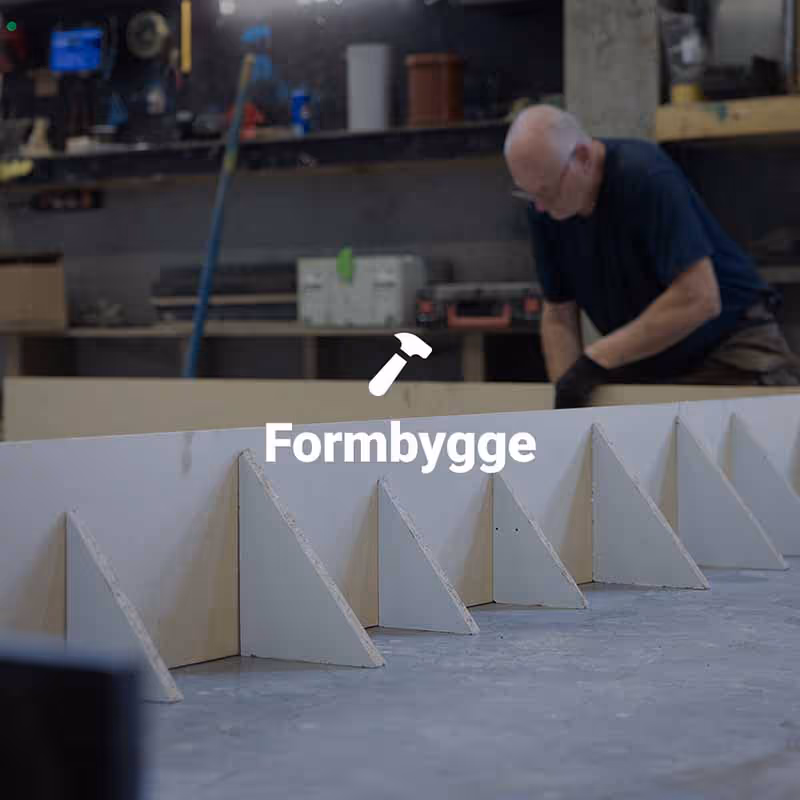 En formsnickare monterar ihop en form för att gjuta ett betongelement. 