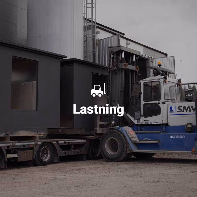 Stor truck lastar ett prefabricerat teknikhus i betong på en lastbil.