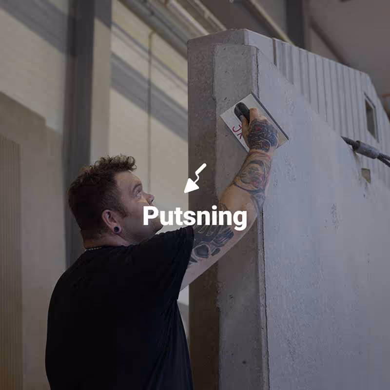 Betongarbetare slipar och putsar kanterna på en prefabricerad betongvägg. 