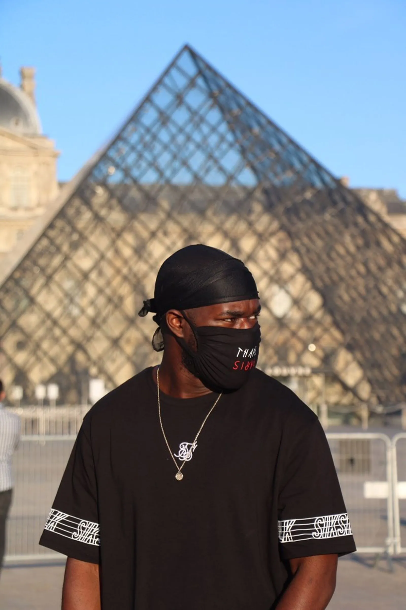 Person_in_front_of_Louvre_Pyramid
