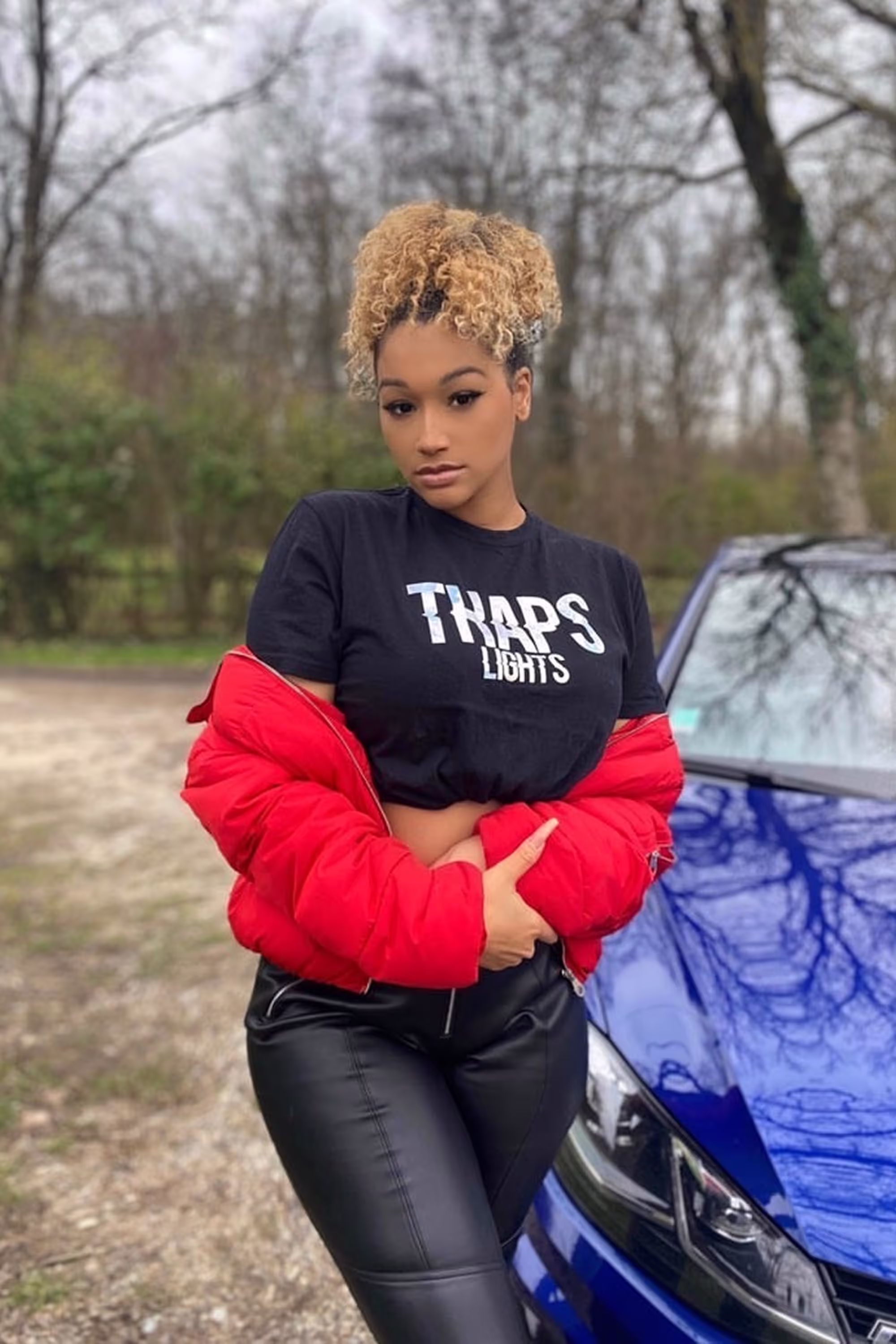 Person_posing_near_blue_car