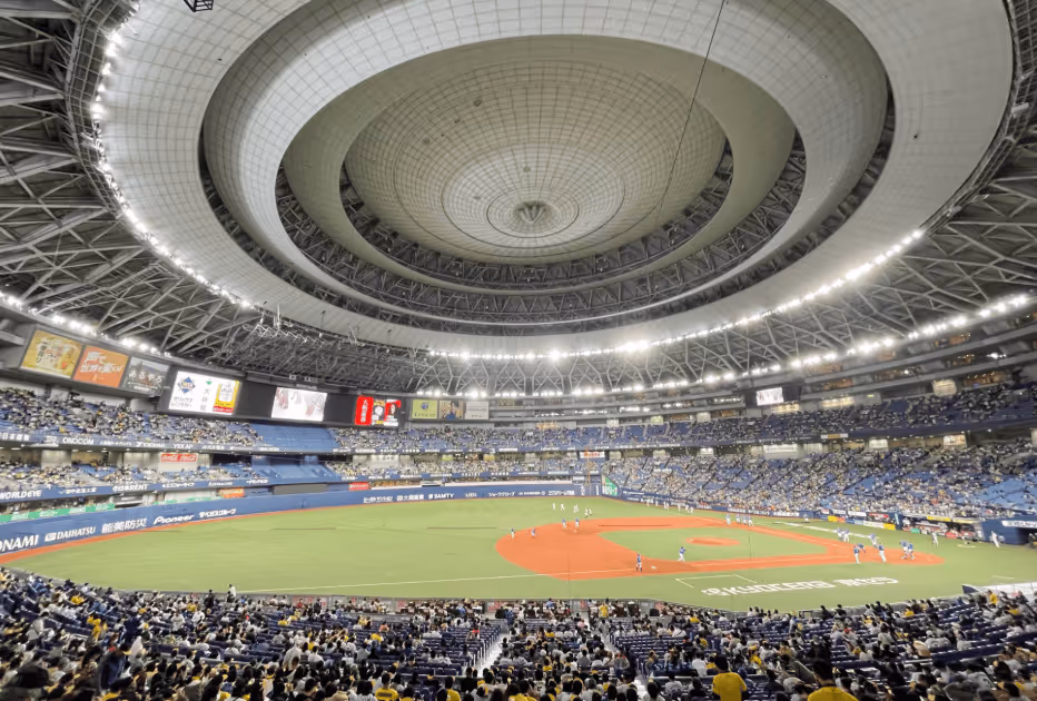 Wide view of an indoor baseball stadium with a game in progress and a large crowd of spectators.