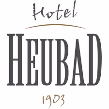 Logo with the text 'Hotel HEUBAD 1903' featuring stylized fonts.