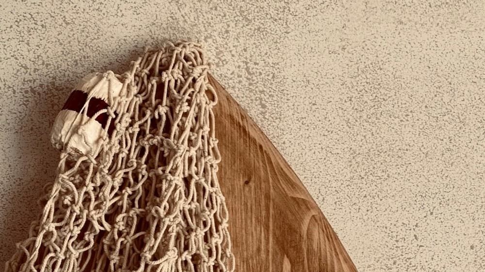 surf board with netting on top and rough wall background