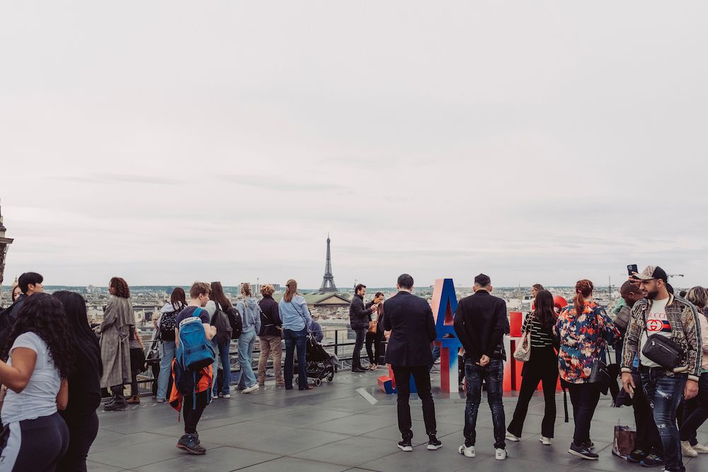 people atop the Galeries Lafayette with a view to the eiffel tower