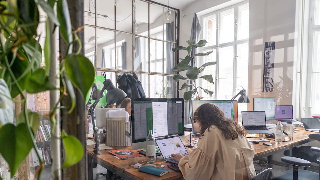 People working in an office with plants and open space