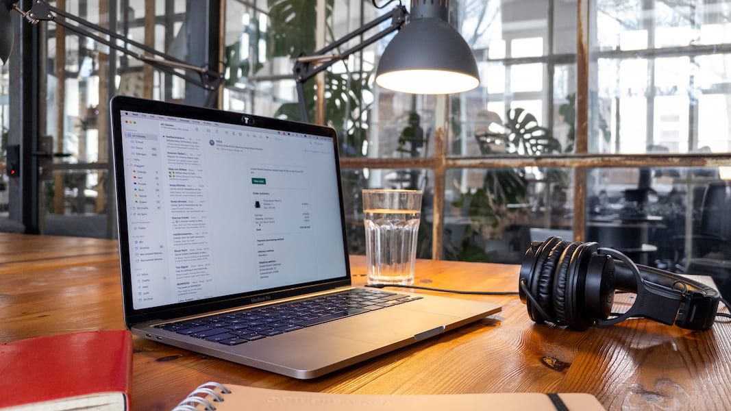 Open laptop with a lamp and headphones at an office building