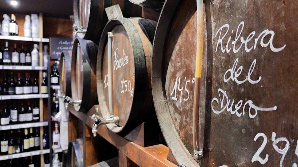 Barels of wine with bottles in the background