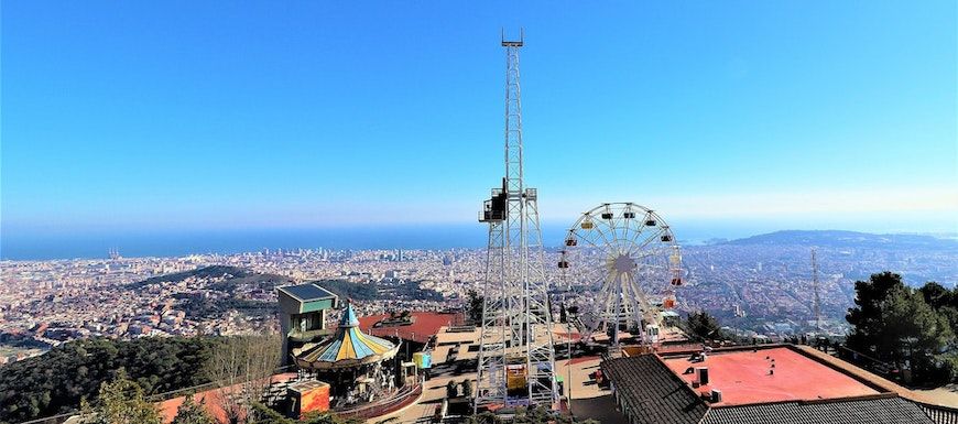 Atracciones de un parque de atracciones en lo alto de una colina, con vistas desde el Tibidabo