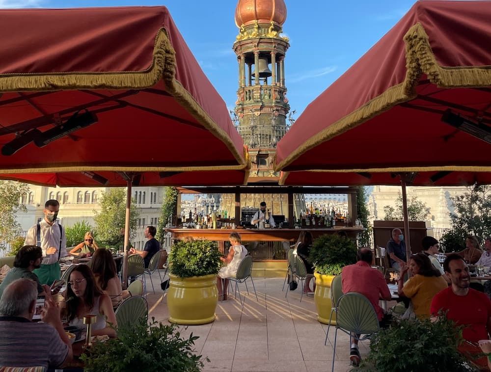 Tables and people on a rooftop enjoying a drink