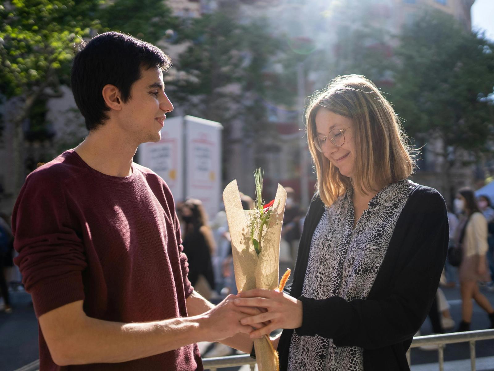A young man offering a red rose to his girlfriend as a proof of love