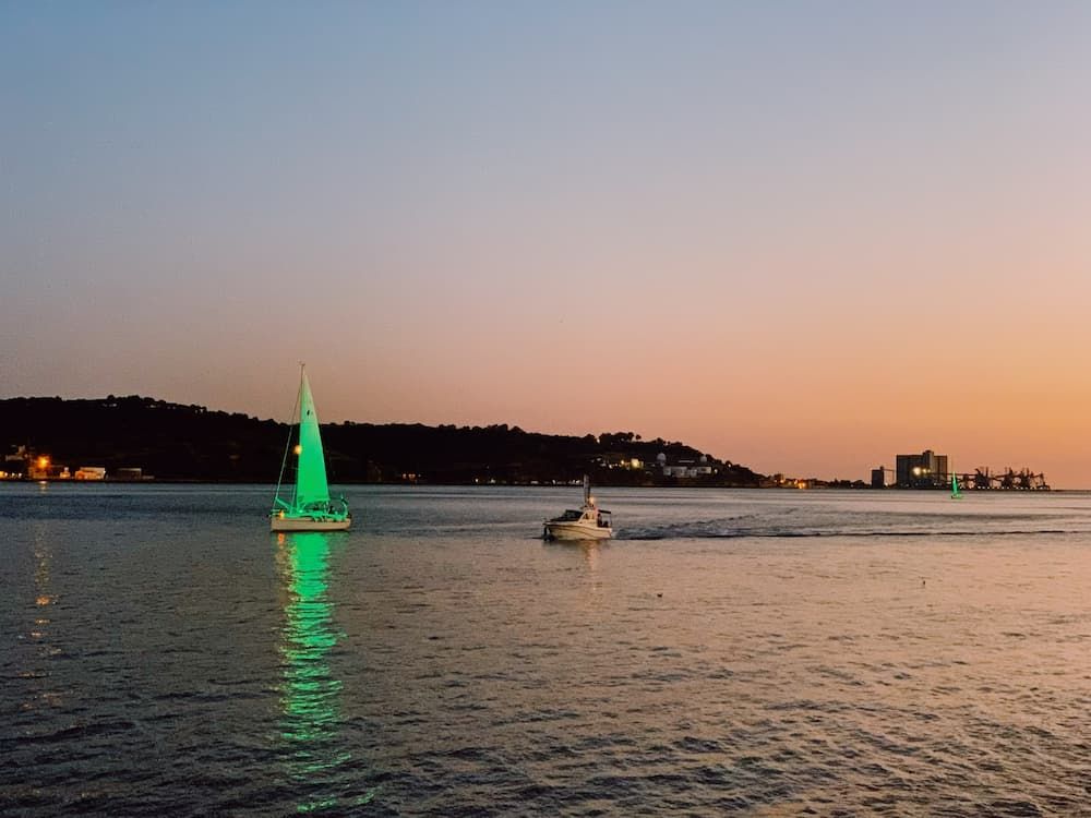 Lisbon waterway with boats lit up at sunset