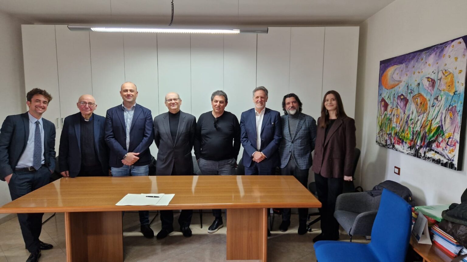 Il gruppo fondatore di REF riunito attorno a un tavolo in un ambiente formale.