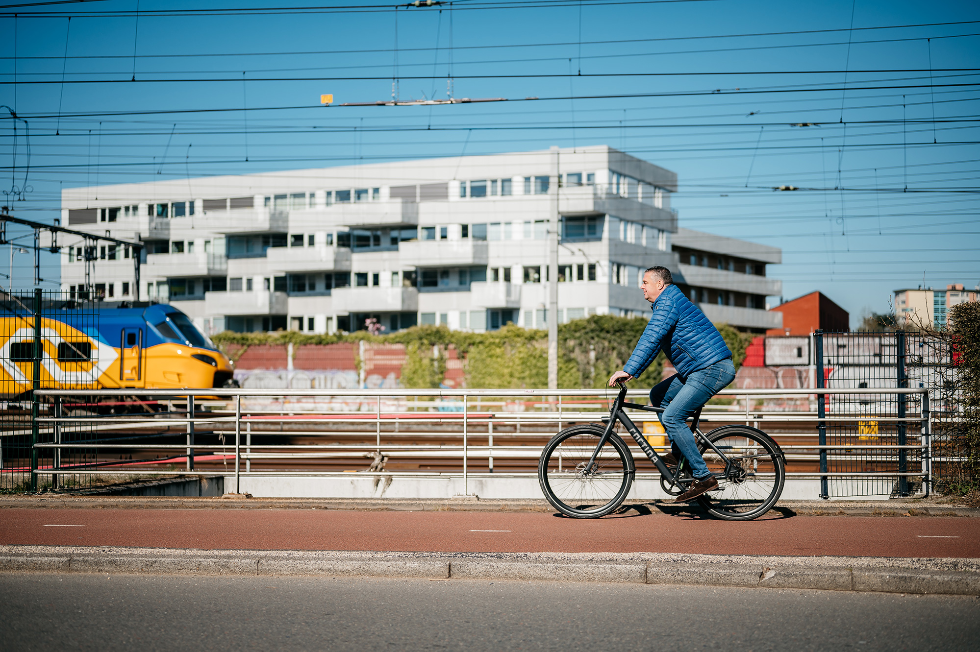 Medewerker op de fiets naast een treinspoor