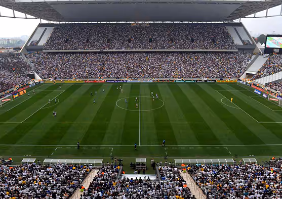 Full stadium view of Arena de São Paulo during a live soccer match, showcasing a well-maintained pitch and packed spectator stands