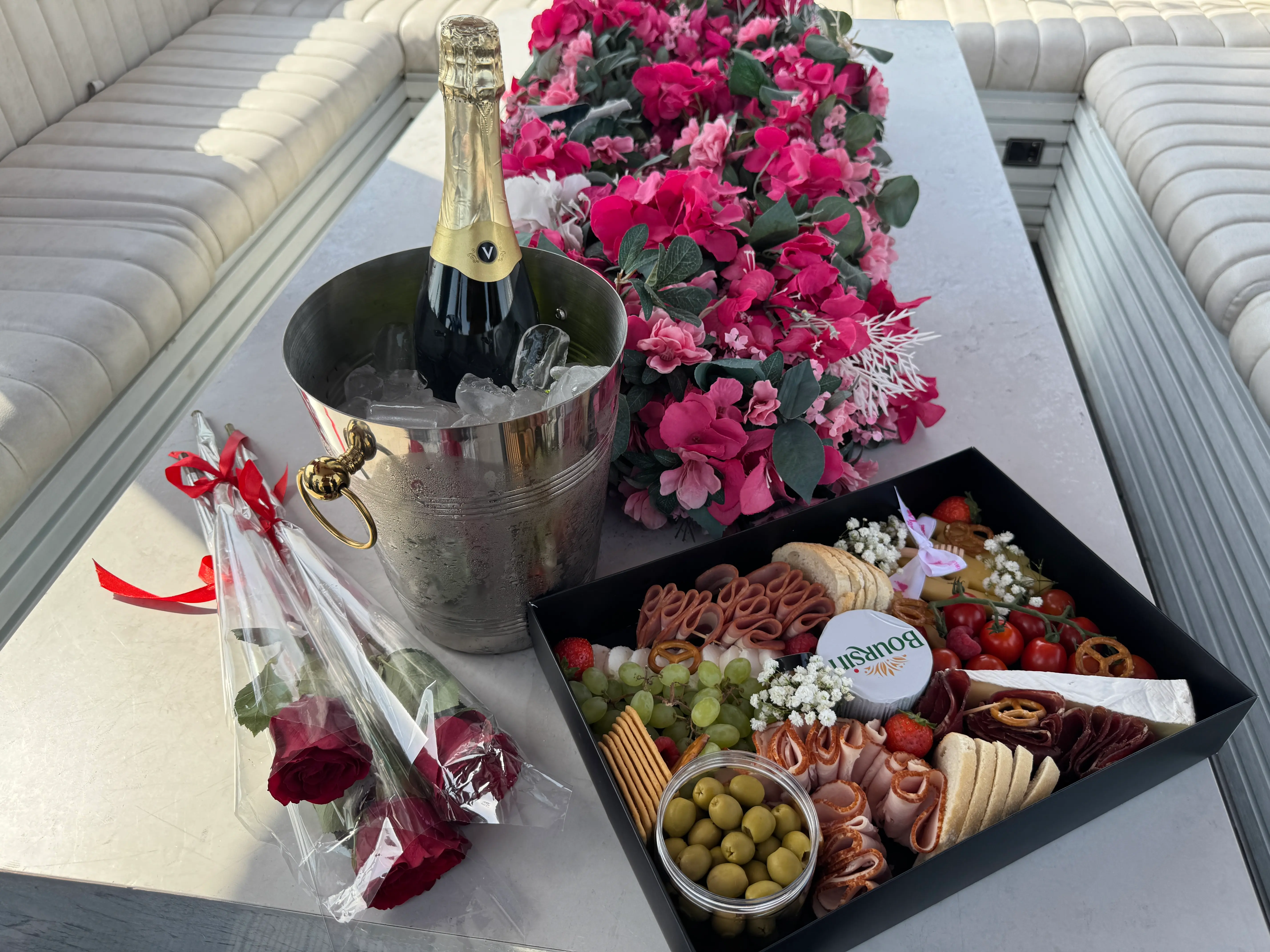 A delicious food board with champagne and roses