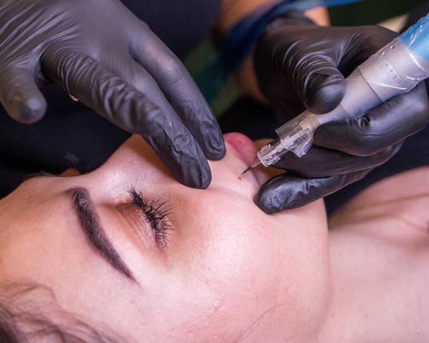 Artist applying semi-permanent beauty spot
