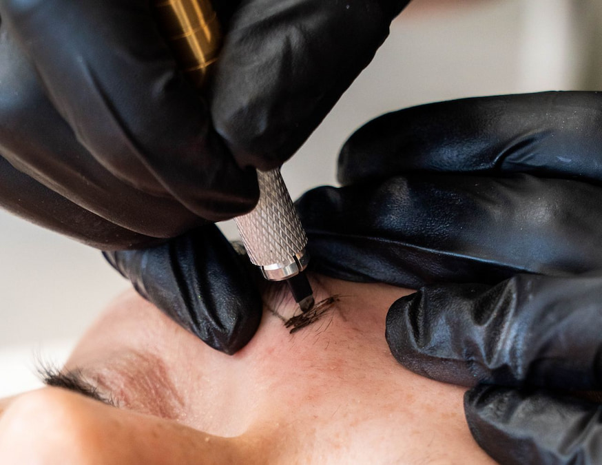 Artist reapplying pigment to the brow during the session